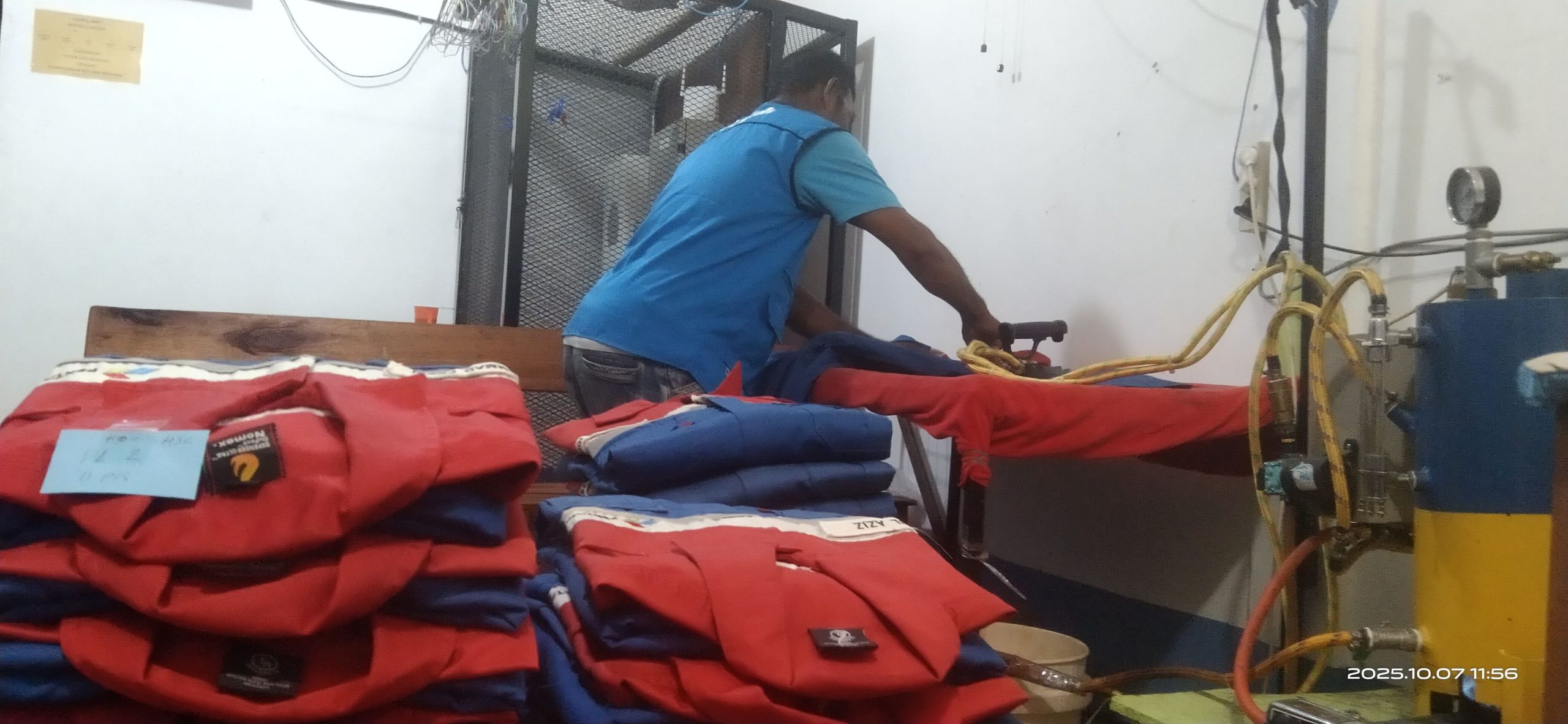 Seorang pekerja Betuah Laundry tengah menyetrika pakaian kerja pelanggan. Usaha binaan Pertamina ini mengedepankan efisiensi energi dan ramah lingkungan.