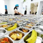 Petugas tengah memorsi menu Makan Bergizi Gratis di dapur Satuan Pelayanan Pemenuhan Gizi